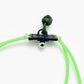 Green slingshot with a black anchor and silver ball on a white background, featuring a brand logo in the corner.