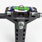 Close-up of a motorcycle handlebar riser with green grip pad and purple accents on a white background.