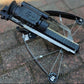 Crossbow with scope on a brick surface.